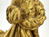 golden statue of a woman with long hair on a white background