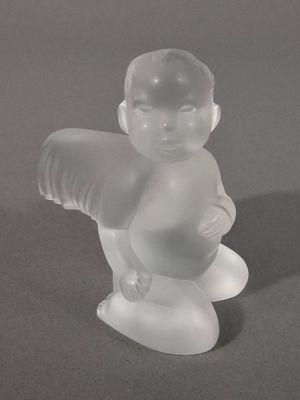 une figurine en verre représentant un bébé assis sur une table