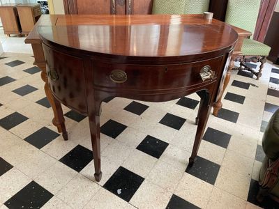 a wooden table with a glass top on a black and white checkered floor