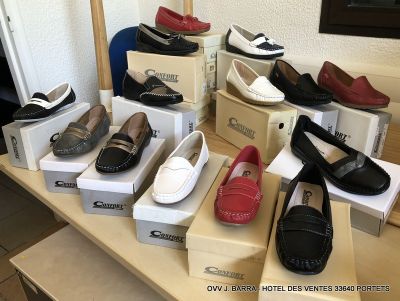 de nombreuses paires de chaussures posées sur une table dans une pièce