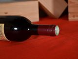 a bottle of wine sitting on a table next to a wooden box