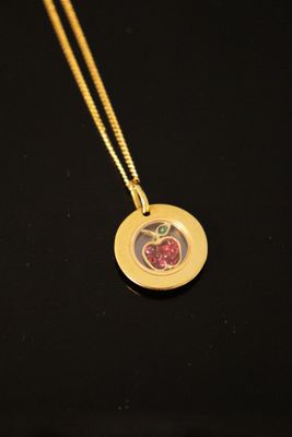 a gold necklace with an apple charm on it