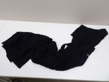 a white table with a pair of black pants on it