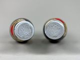 pair of red and white wine bottles sitting on top of a table