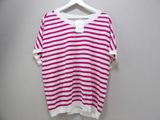 pink and white striped t - shirt on hanger against white wall