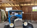 une vieille voiture qui prend la poussière dans un garage