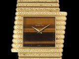 un gros plan d'une montre-bracelet dorée sur fond noir