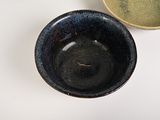 two bowls sitting on a table with one empty one