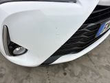 the front end of a white car with a black bumper