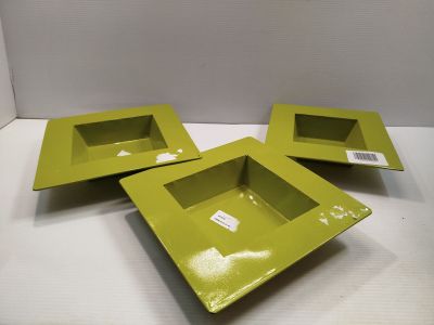 trois plats carrés verts avec leurs couvercles sont posés sur une surface blanche