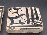 two stone coasters with designs on them on a table