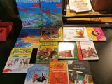 Plusieurs livres pour enfants sont posés sur un bureau, devant une lampe.