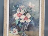 tableau représentant des fleurs blanches dans un vase en verre posé sur une table