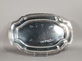 une assiette ancienne en argent, ornée d'un motif décoratif sur le bord
