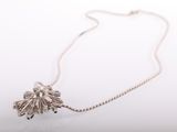 a close up of a silver necklace with a flower on it