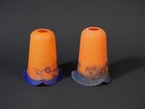 une paire de cônes en plastique orange et bleu posés sur une surface noire
