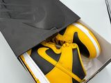 a box with a pair of yellow and black sneakers inside of it