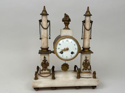 a white marble clock on a stand with chains around it