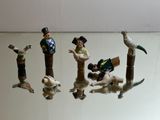 five figurines of people and animals on a glass table