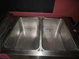 two sinks that are in a kitchen with a red wall