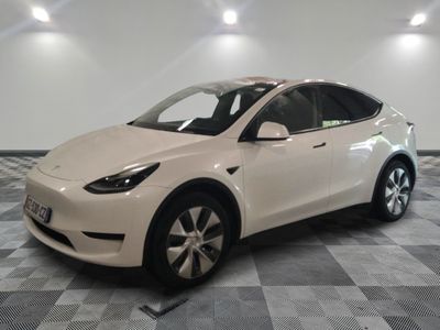 La Tesla Model X blanche est garée dans une pièce dont le sol est à carreaux.