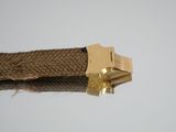 a close up of a piece of rope with a gold buckle