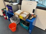 a desk with a whiteboard and a bucket of food on it