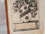an old book with a picture of a coat of arms on it