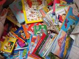 many children ' s books in a box on the bed