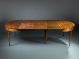 an oval dining table with two leaves on the top and two leaves on the bottom