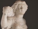 marble statue of a woman holding a cat on her shoulder