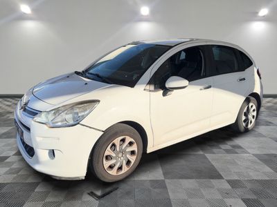 the small white car is parked in a room with a checkered floor