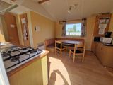 une photo d'une cuisine et d'un coin repas dans un mobil-home