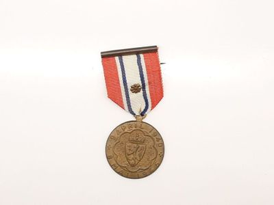une vieille médaille entourée d'un ruban rouge, blanc et bleu