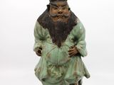 statue d'un homme barbu et coiffé d'un chapeau, assis sur un socle noir