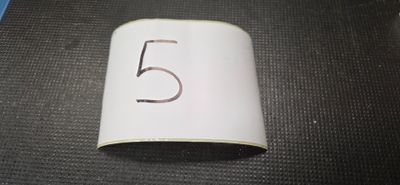 un « 5 » inscrit sur un rouleau de papier posé par terre