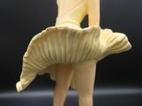 une figurine représentant une femme en robe jaune