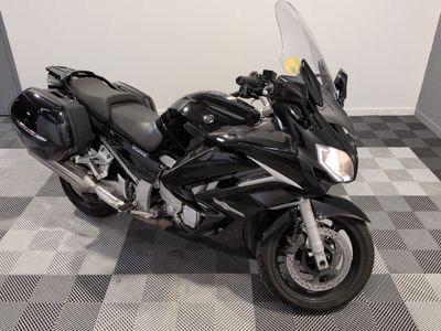 une moto noire garée sur un sol à damier