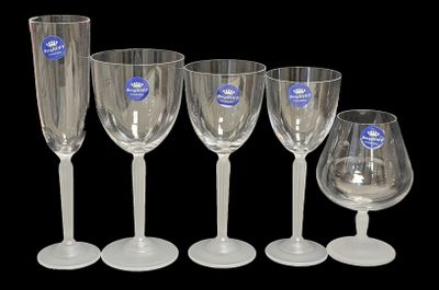 quatre verres à vin transparents sont alignés sur un fond noir