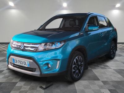 Un SUV bleu est garé dans une pièce dont le sol est à carreaux.