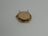a small gold watch on a white surface with a white background