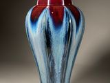 un vase bleu et rouge avec un socle doré