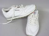 pair of white sneakers with white laces on them on a table