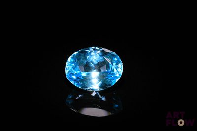 a close up of a blue diamond on a black surface