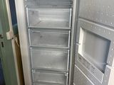 an empty refrigerator in the corner of a room