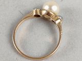 a close up of a gold ring with a pearl on it