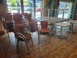 many chairs and tables in a room with a lot of windows