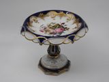 a small blue and gold plate with a flower on it