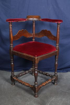 une vieille chaise en bois avec une assise en velours rouge sur fond bleu