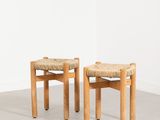 deux tabourets en bois avec des assises tressées dans une pièce vide